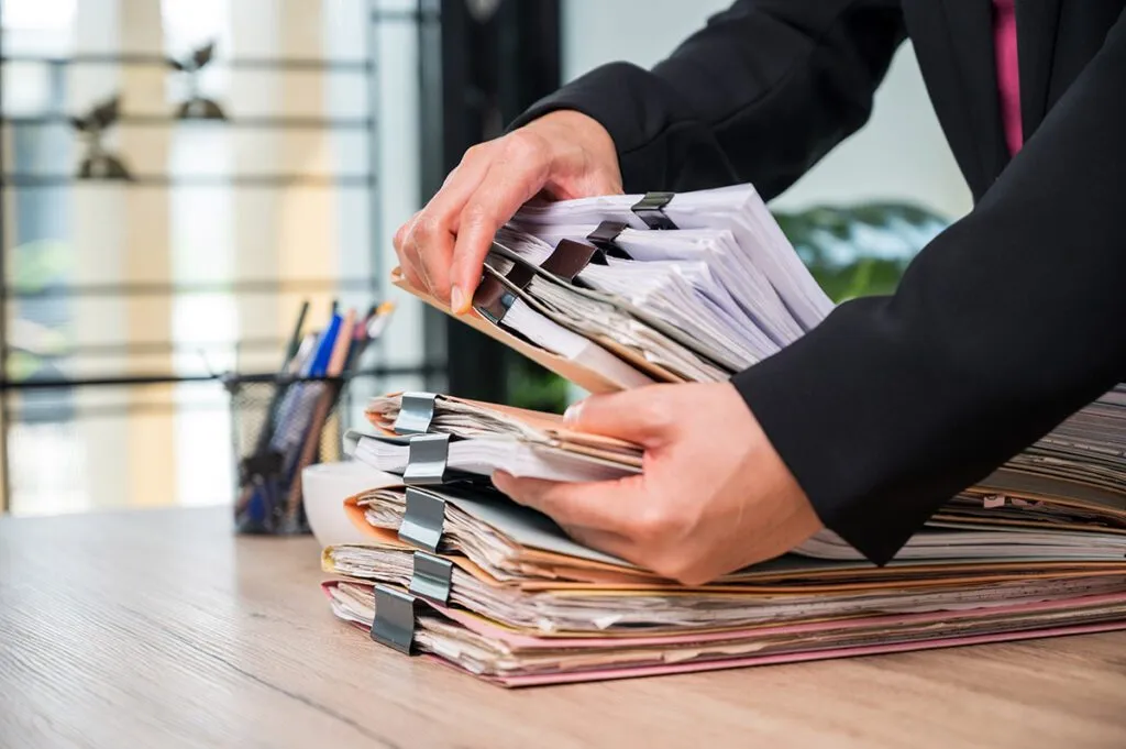 A member of the City Auditor's team shuffles through various document folders